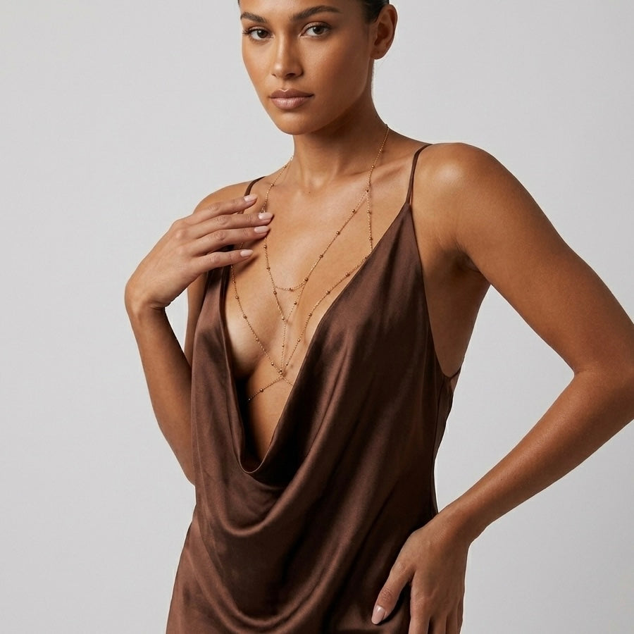 Woman wearing a brown slip dress against a plain background  Peek-a-boo Body Chains - The Songbird Collection