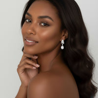 Woman wearing elegant earrings with a neutral background