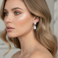Close-up of a woman wearing elegant earrings with a neutral background
