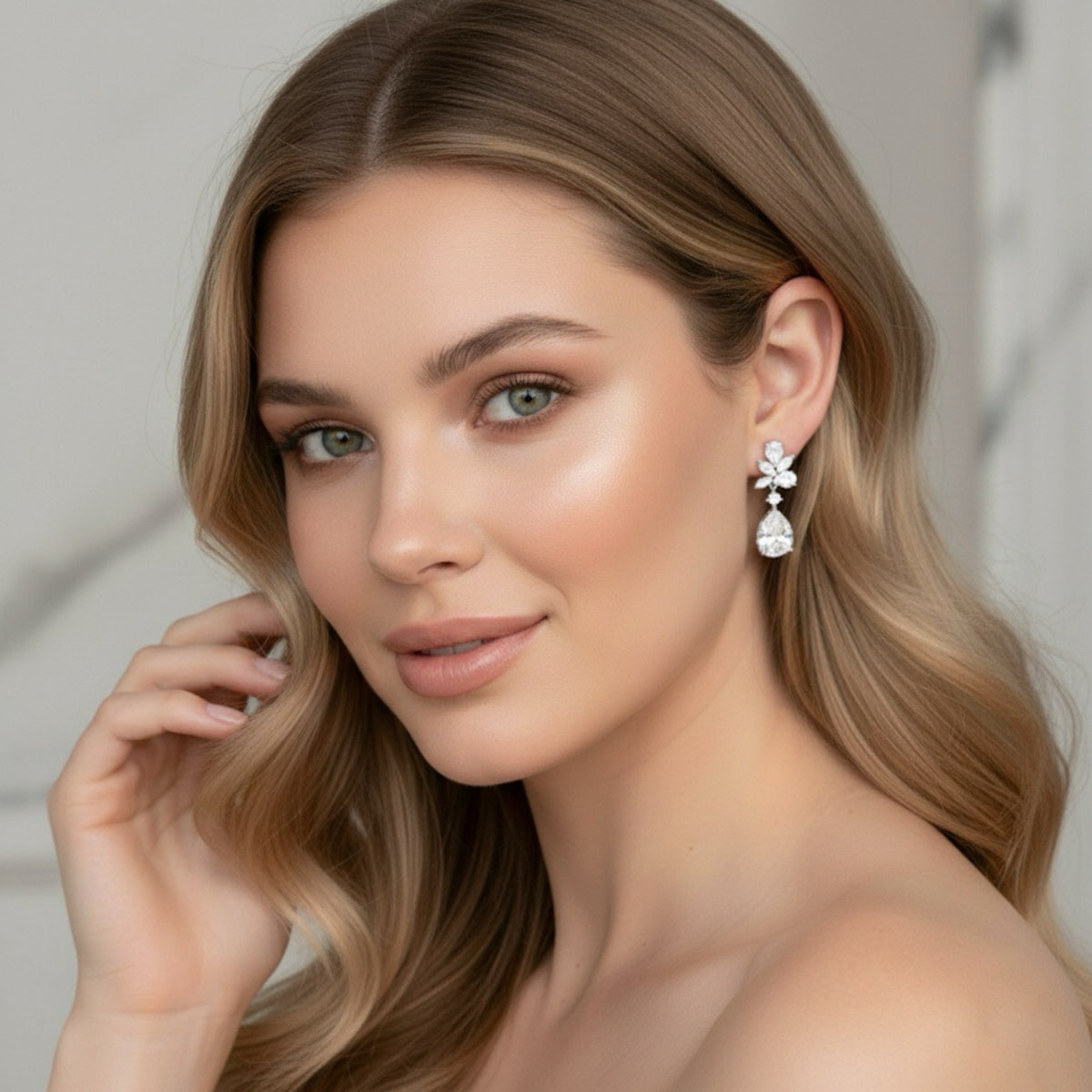 Woman wearing a pair of floral diamond drop bridal earrings with a neutral background
