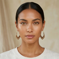 Woman wearing gold hoop earrings and a necklace against a beige background - Priya Vintage Metal Earrings - The Songbird Collection