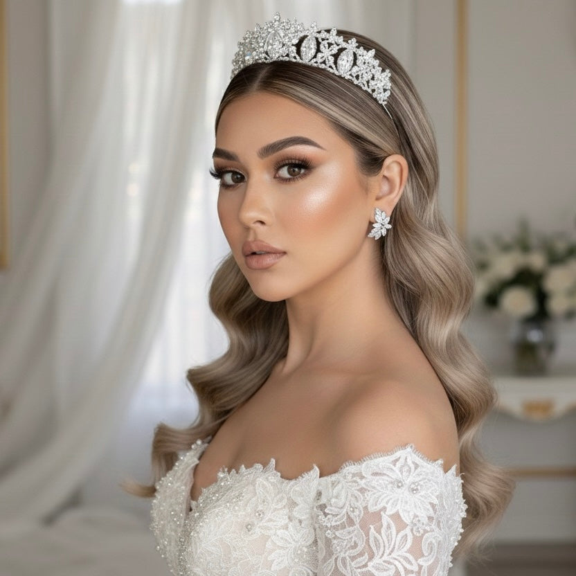 A bride wearing a white wedding dress and tiara with floral petal shaped diamond earringsin a elegant indoor setting