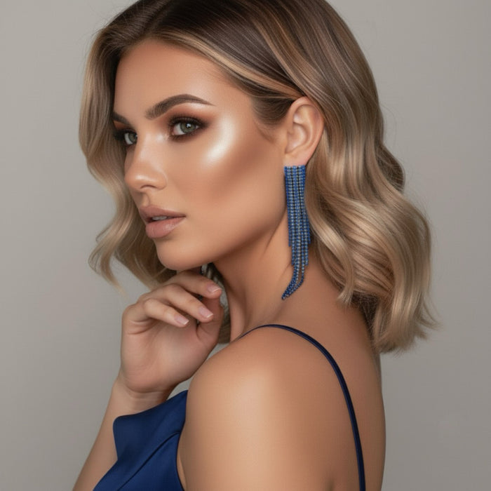 Woman wearing blue earrings with a neutral background