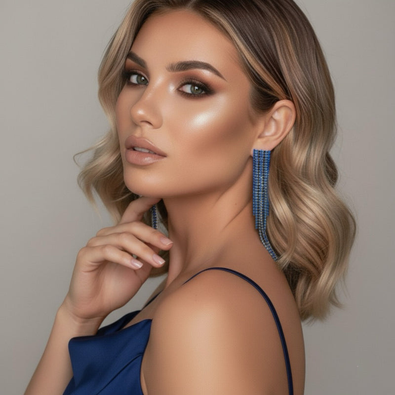 Woman wearing blue earrings with a neutral background