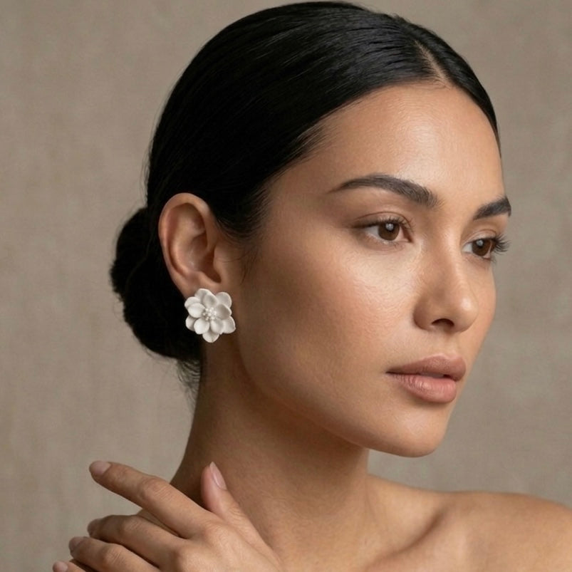 Woman wearing a white floral earring against a neutral background. Rosalie Earrings - The Songbird Collection