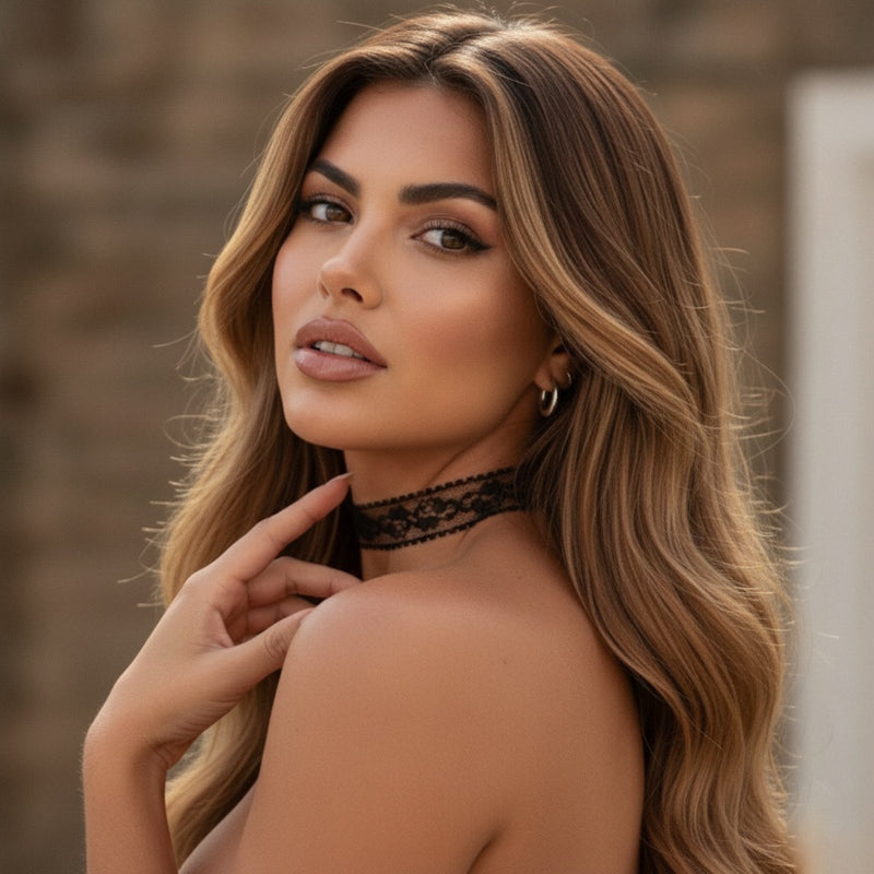 Woman with long, wavy hair wearing a black lace choker against a blurred background