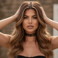 Woman with long, wavy hair wearing a black choker against a blurred background