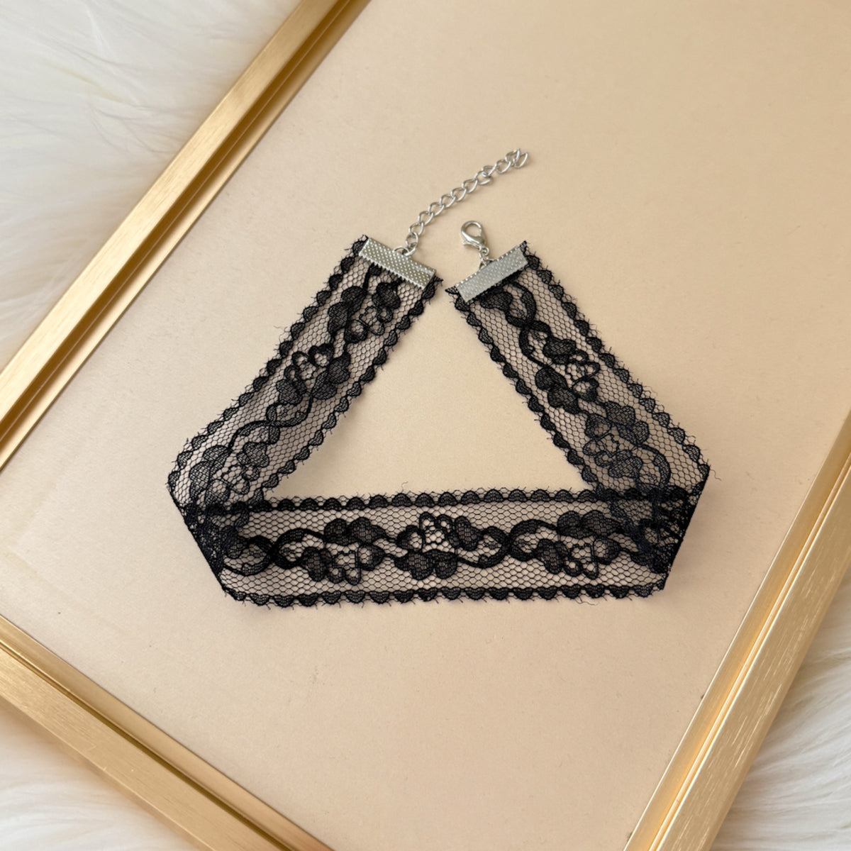 Black lace choker necklace on a beige background