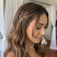 A woman with long, wavy brown hair with blonde highlights wearing a silver safety pin hair clip, shown in a softly lit indoor setting. Safety Pin Hair Pin Set - The Songbird Collection