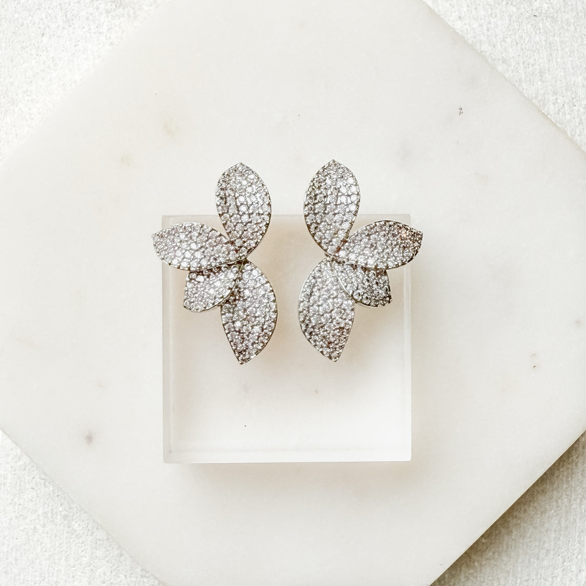 Pair of sparkling butterfly-shaped earrings on a white background. Seraphine Earrings - The Songbird Collection - pave - floral petal