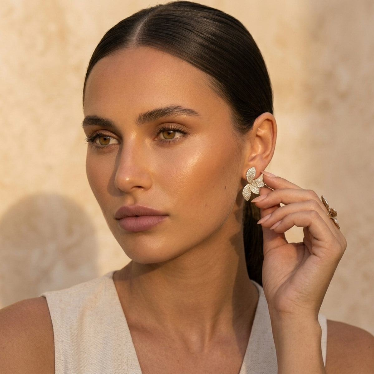 Woman wearing earrings with a neutral background. Seraphine Earrings - The Songbird Collection - pave - floral petal