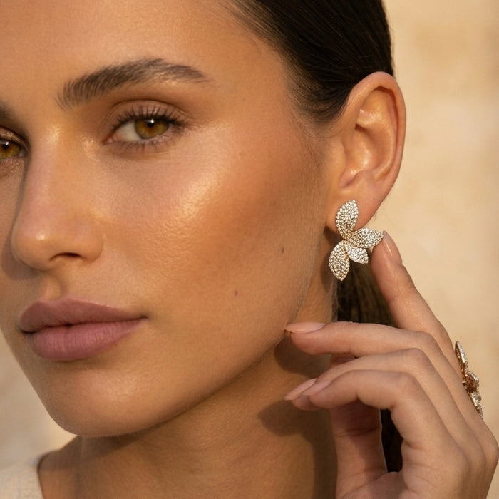 Close-up of a woman wearing a sparkling butterfly earring against a neutral background