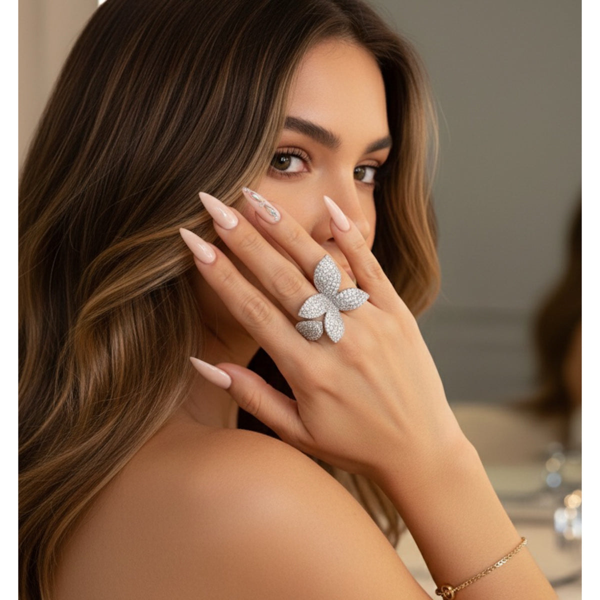 Woman wearing a flora/petal/butterfly-shaped diamond ring with a blurred background