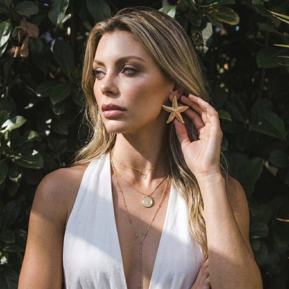 Woman wearing starfish earrings in a natural setting  Starfish_Statement_Earrings_-_The_Songbird_Collection_