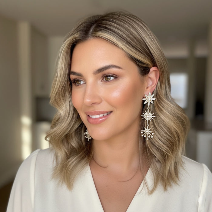 Woman wearing star-shaped earrings with a blurred indoor background
