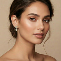 Close-up of a woman wearing butterfly earrings with a neutral background  Sweet Butterfly Earrings - The Songbird Collection