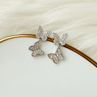 Butterfly-shaped earrings on a white plate with a gold rim  Sweet Butterfly Earrings - The Songbird Collection