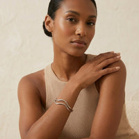 Woman wearing a beige sleeveless top and silver bracelet against a neutral background. The_Contour_Cuff_Bracelet_-_The_Songbird_Collection_
