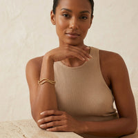 Woman wearing a beige sleeveless top against a neutral background - The Contour Cuff Bracelet - The Songbird Collection