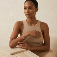 Woman wearing a beige ribbed tank top sitting at a tableThe_Contour_Cuff_Bracelet_-_The_Songbird_Collection_