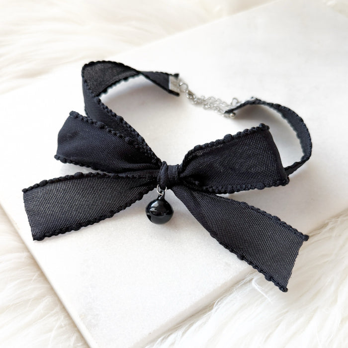 Black bow choker necklace on a white surface