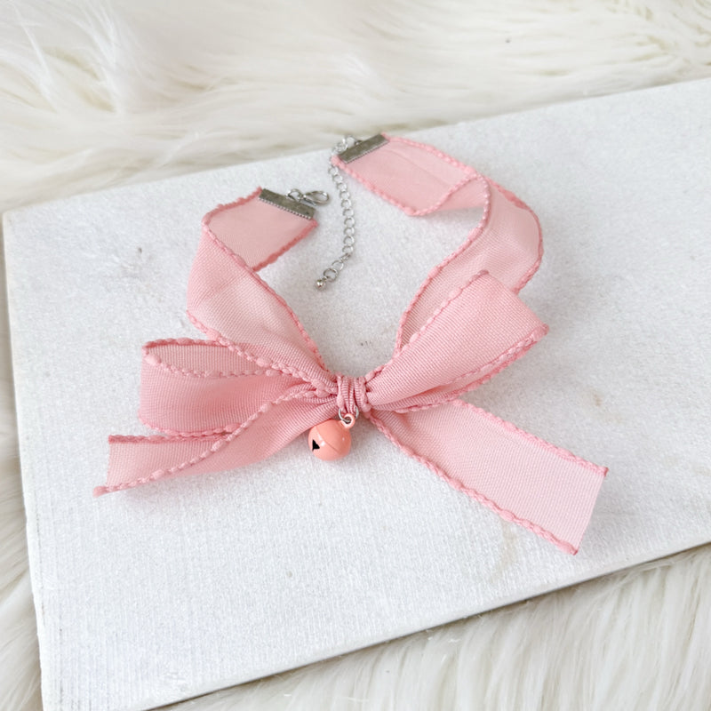 Pink ribbon lace choker on a white card with a soft background