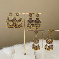 A collection of vintage metal earrings displayed on a stand, featuring bohemian style with ethnic and exotic patterns.